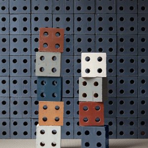 Staplade färgade Bloc block framför en Bloc Blue vägg